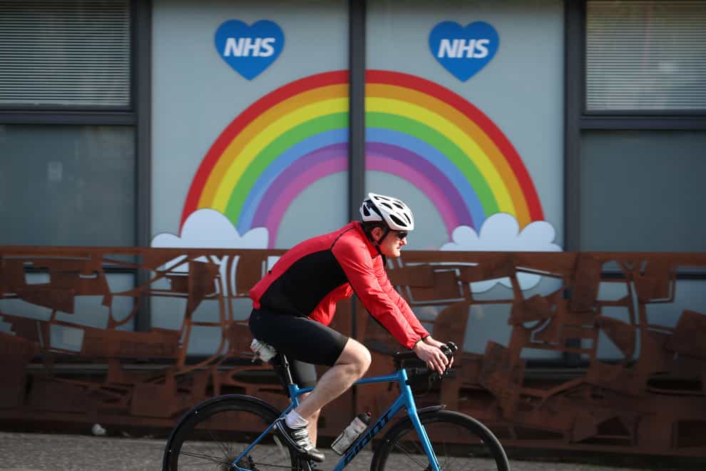 A cyclist passes an NHS tribute painted on a window in Glasgow