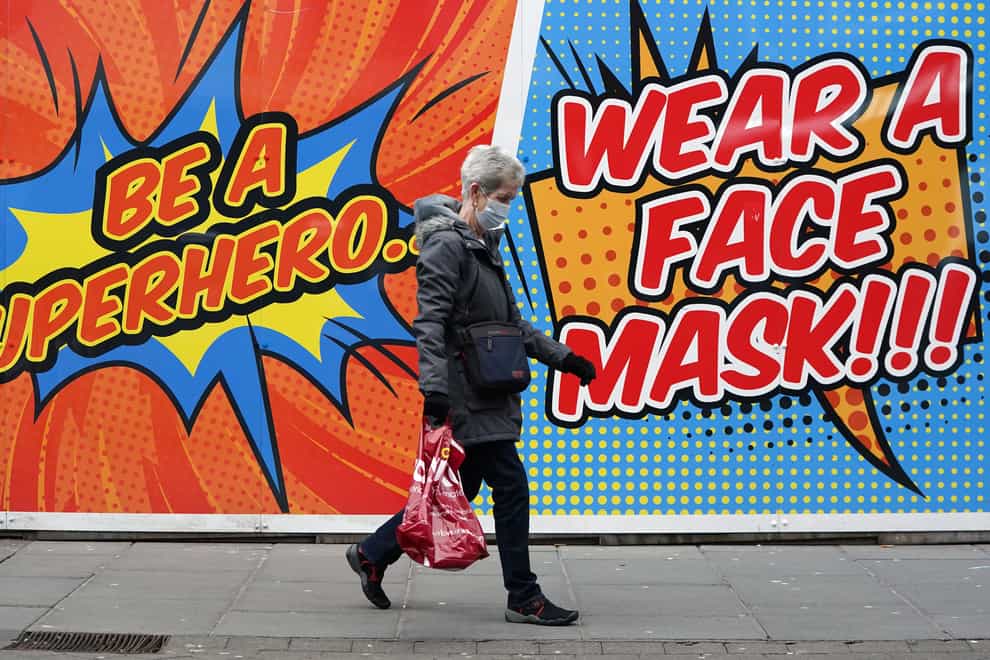 A person walks past a sign telling people to wear a face mask in Nottingham