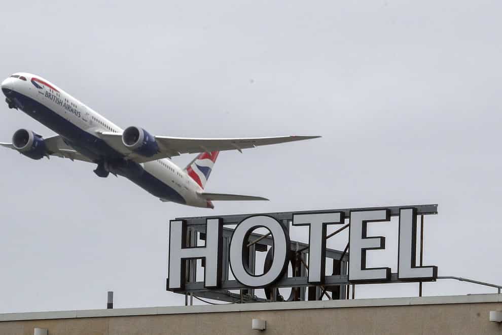 A plane flies over a 'Hotel' sign