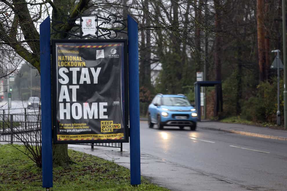 A car drives past a coronavirus information sign in Brookwood, Surrey