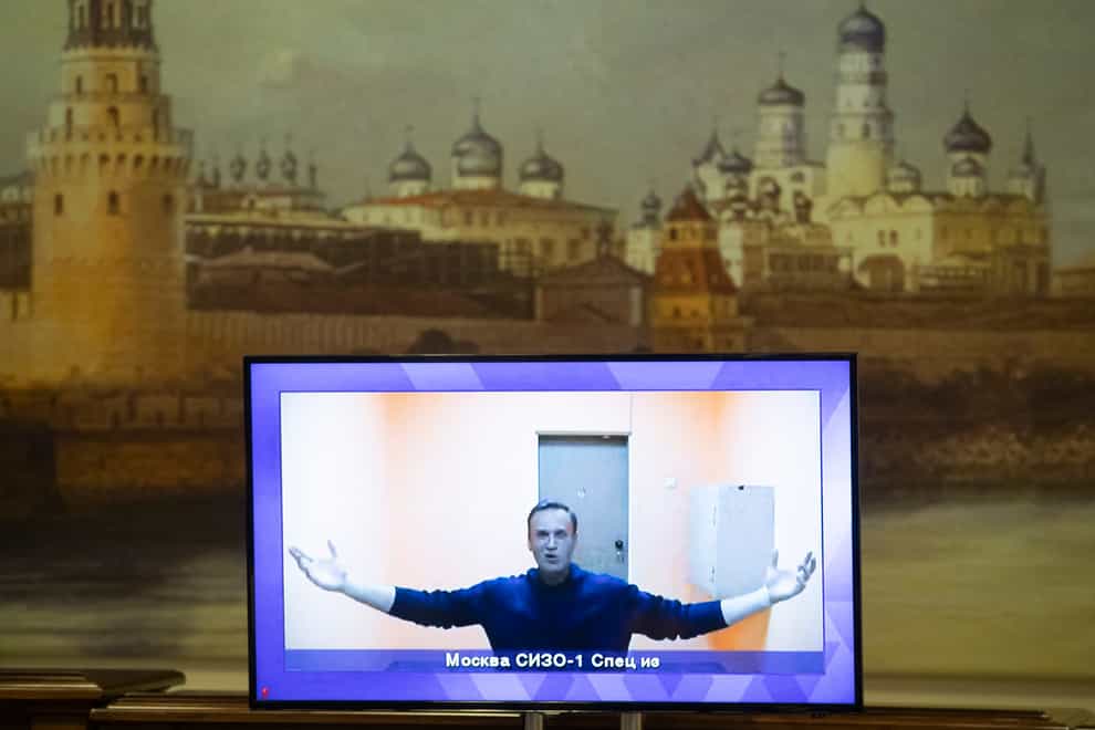 Russian opposition leader Alexei Navalny appears on a TV screen during a live session with the court during a hearing of his appeal in a court in Moscow