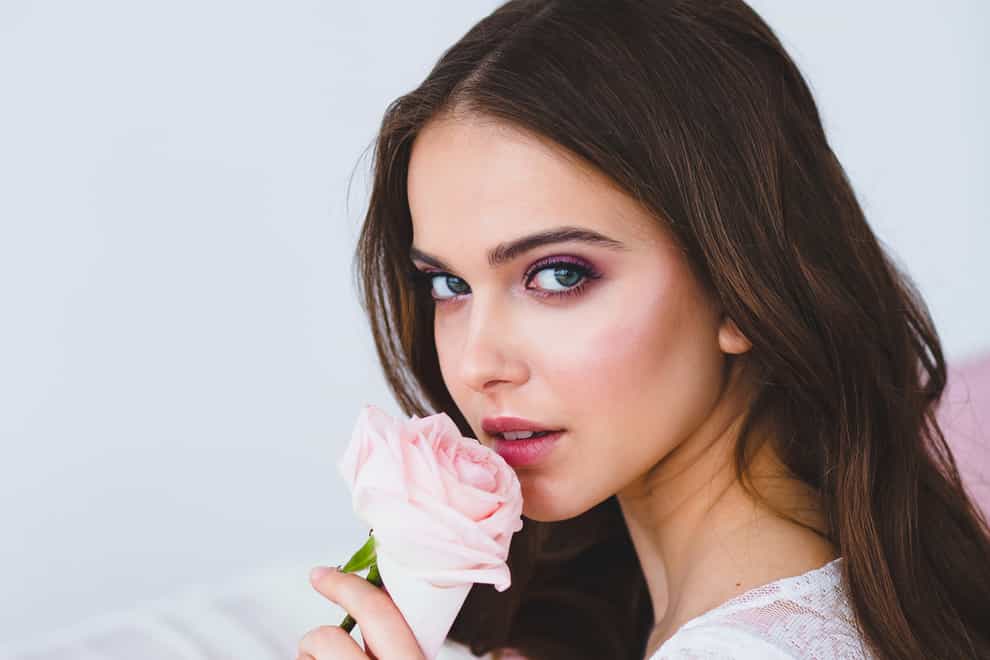 woman smelling a pink rose