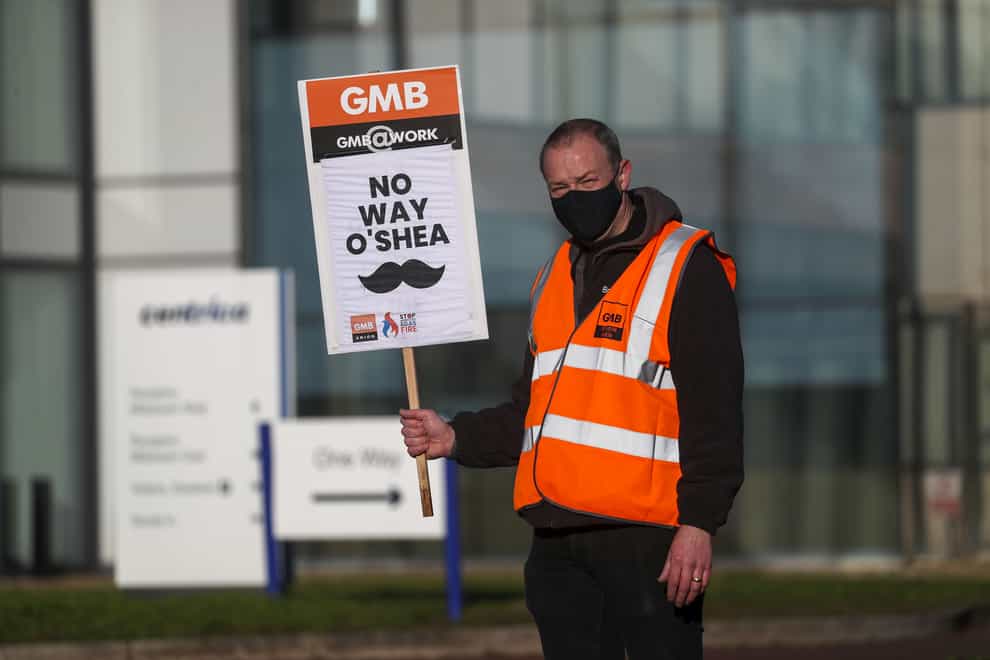 A GMB union member holds a strike placard