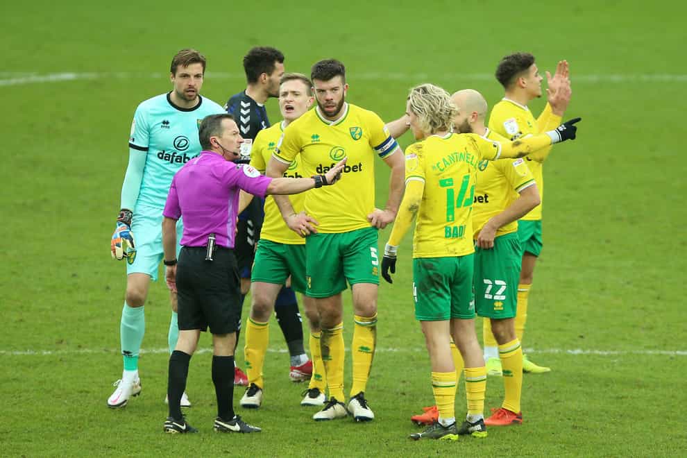 Norwich's players confront ref Keith Stroud after he sent off Emi Buendia