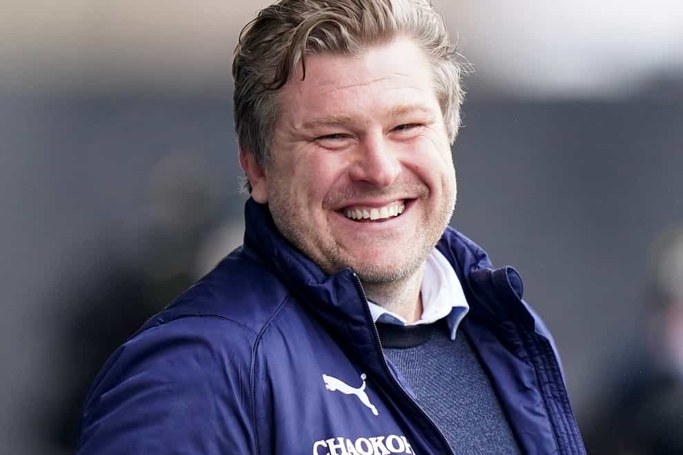 Karl Robinson laughs on the touchline