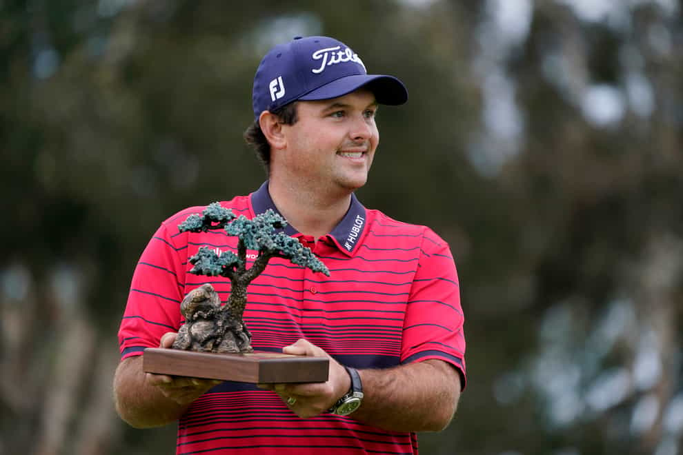 Patrick Reed stands on the South Course while holding his trophy