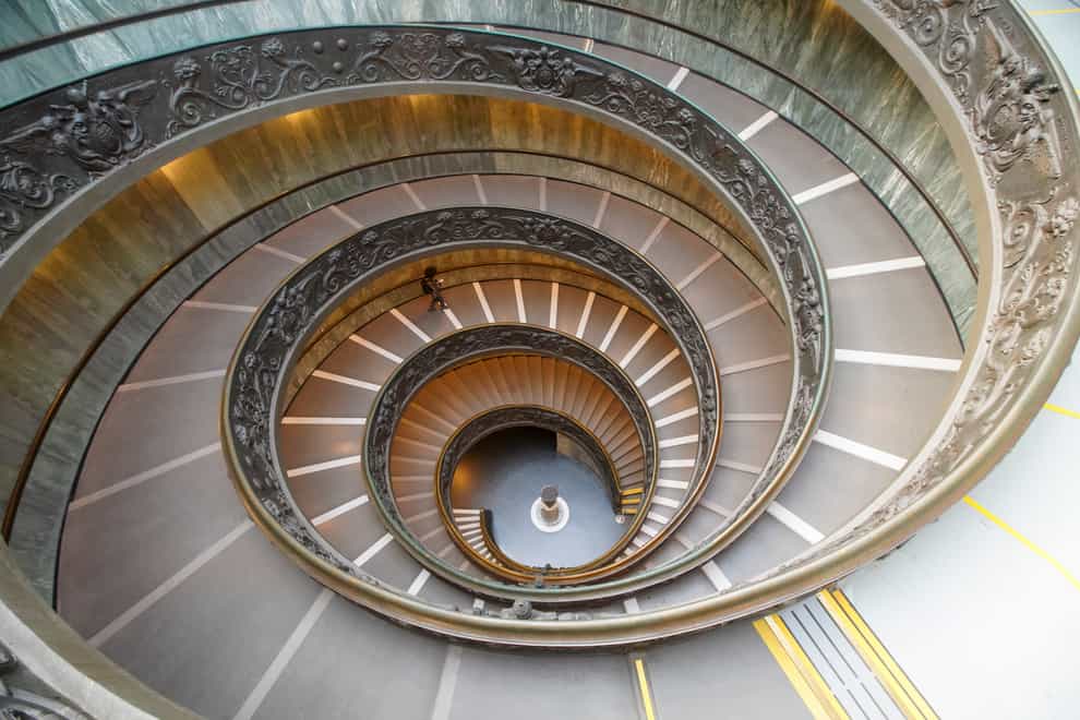 A visitor walks down a staircase, designed by architect Giuseppe Momo in 1932, as she leaves the Vatican Museums (Andrew Medichini/AP)