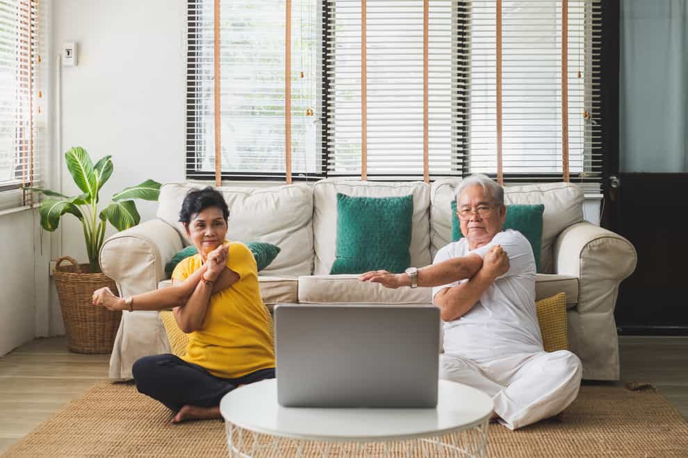 Man and a woman stretching in a living room