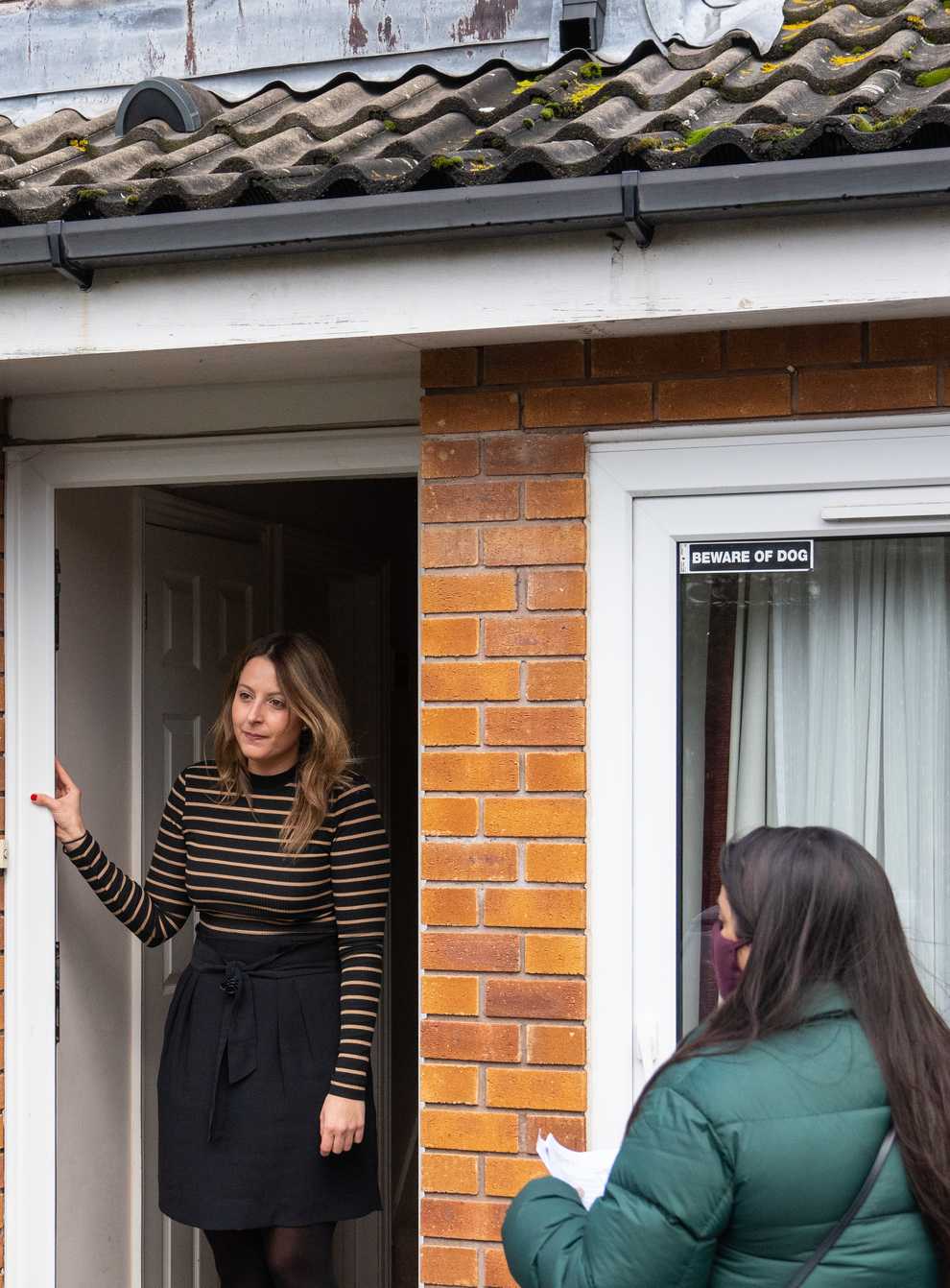 Volunteers speak to residents while carrying out door-to-door coronavirus testing in Woking