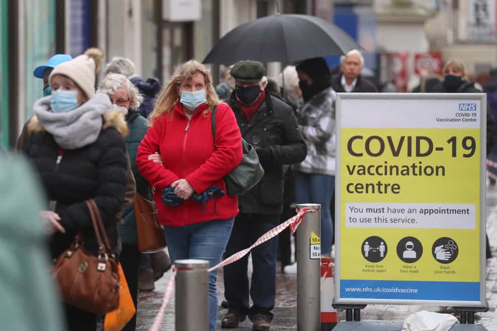 People queue in bad weather outside a Covid-19 vaccination centre