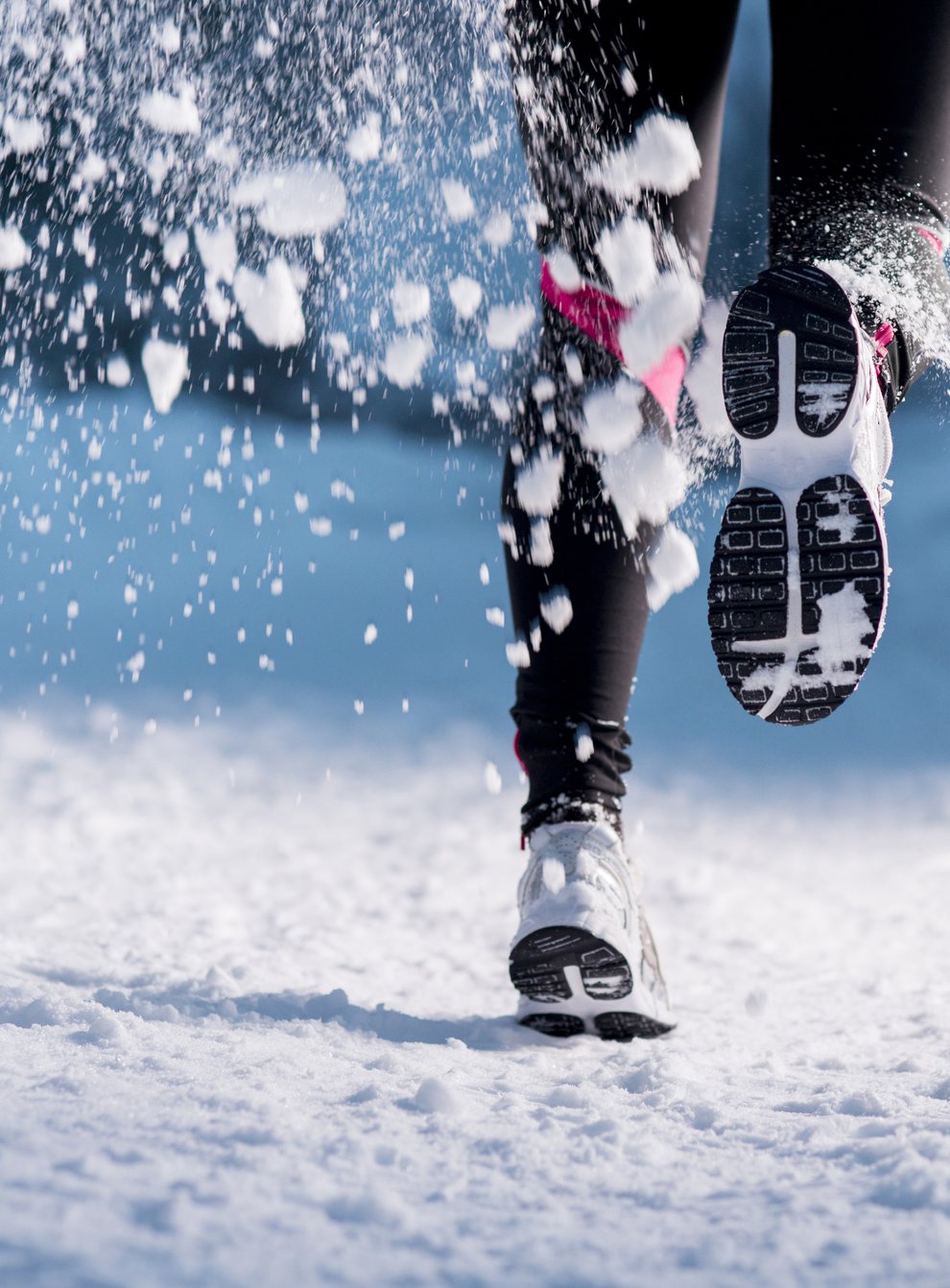 Feet of a woman running in the snow