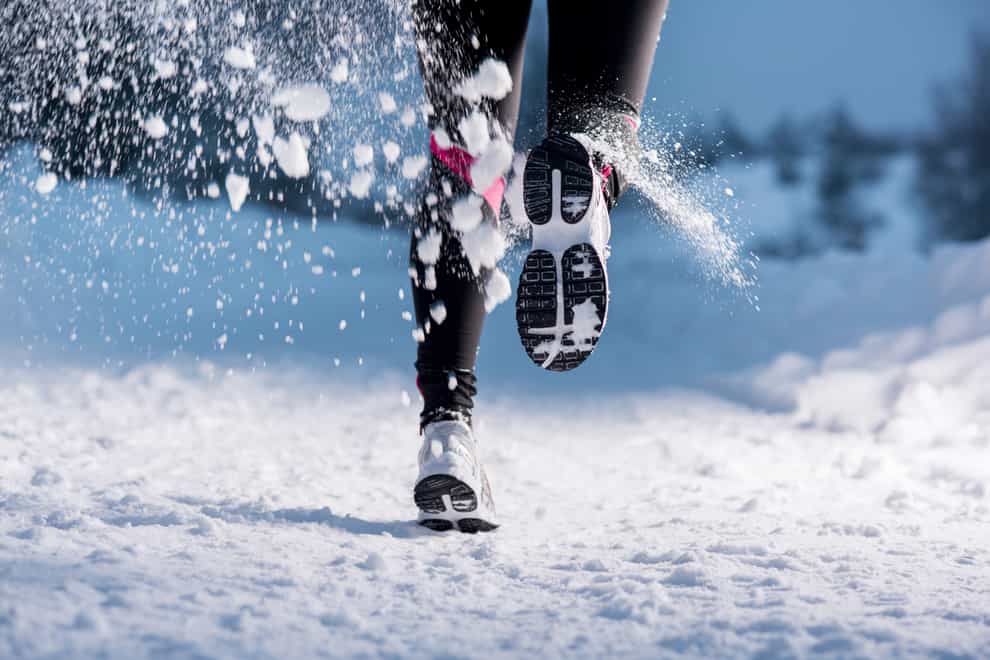 Feet of a woman running in the snow