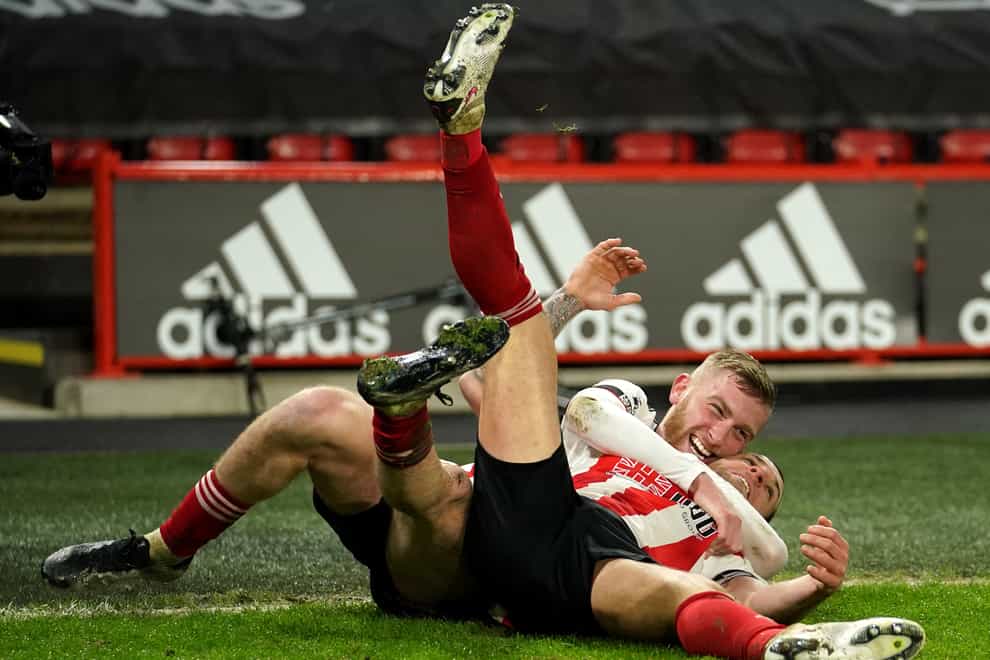 Billy Sharp, right, is tackled by a delighted Oli McBurnie after scoring Sheffield United's winner