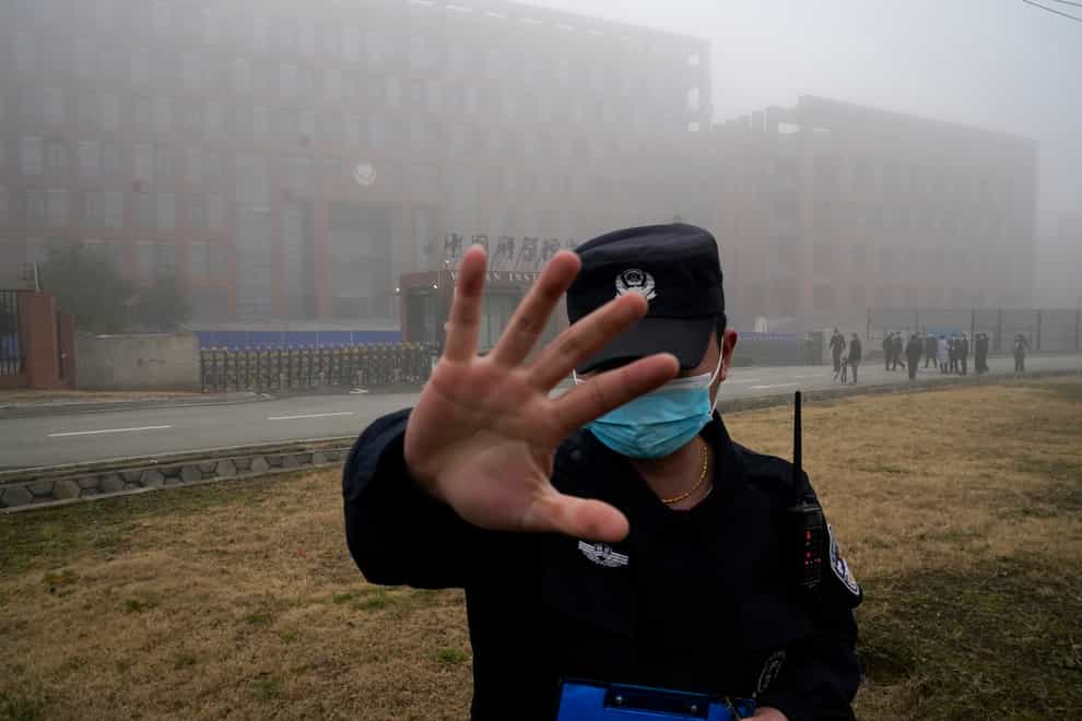 A security guard moves journalists away from the Wuhan Institute of Virology after a World Health Organisation team arrived for a field visit in Wuhan