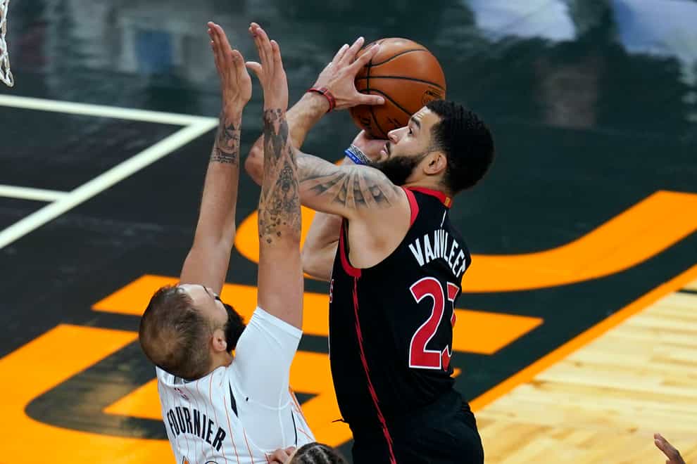 Toronto Raptors guard Fred VanVleet, right, goes up against Orlando Magic guard Evan Fournier for a shot during the second half of an NBA basketball game