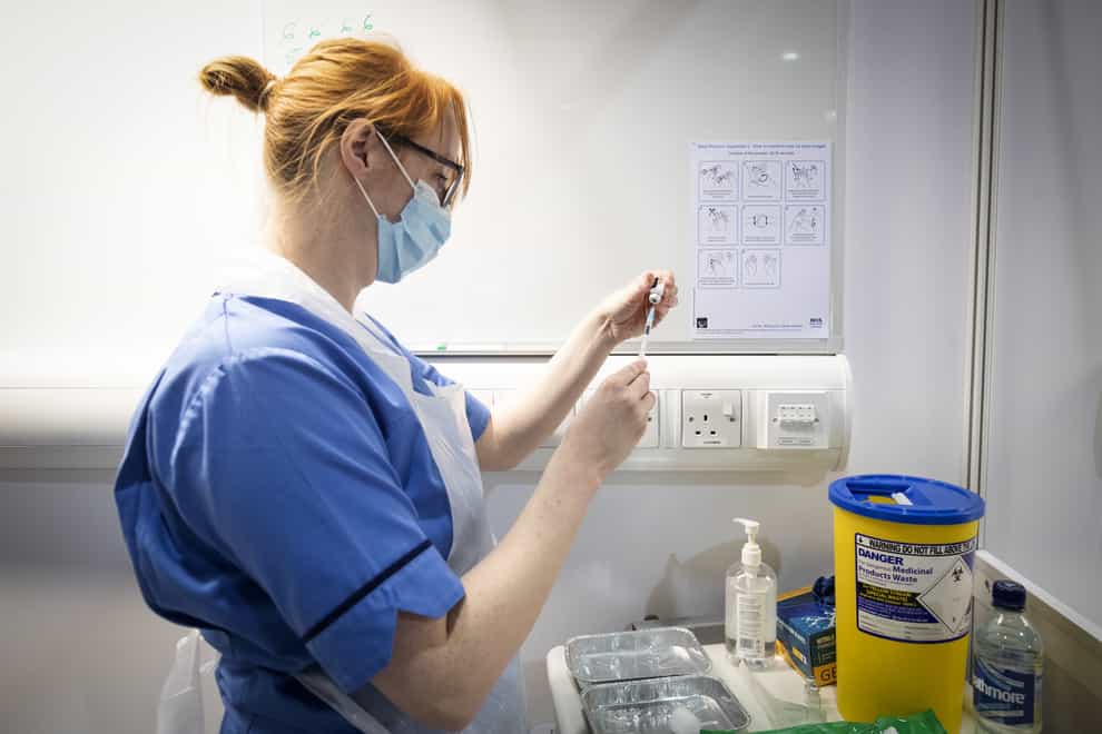 A nurse prepares a coronavirus vaccine to be given to a health and care staff member at the Louisa Jordan Hospital in Glasgow