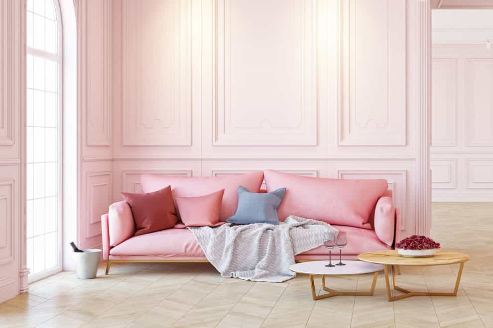 A romantic looking living room with a pink sofa and walls