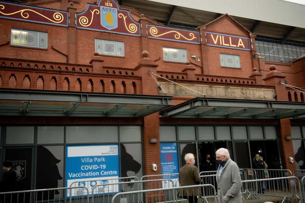 People arrive at a new seven-day vaccination hub at Villa Park, in Birmingham, the home of Premier League club Aston Villa