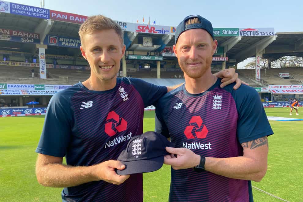 Joe Root (left) receives his 100th Test cap from Ben Stokes (right).