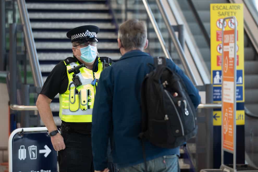 An officer checks that a passenger is travelling for essential purposes