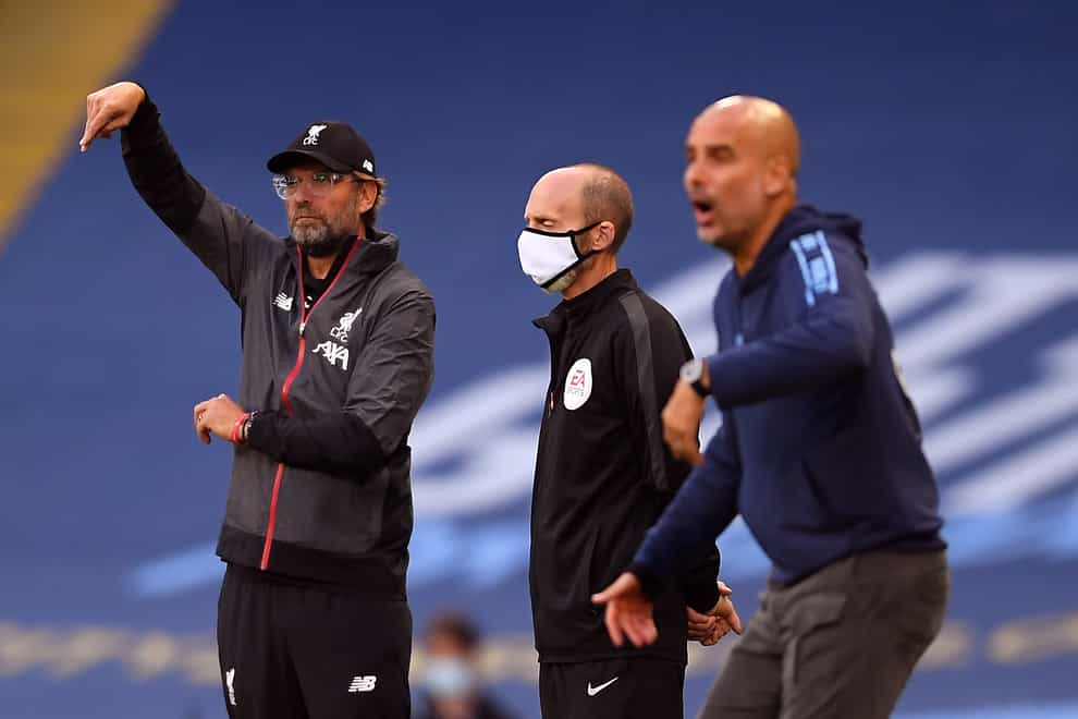Liverpool and Manchester City managers Jurgen Klopp and Pep Guardiola gesture on the touchline