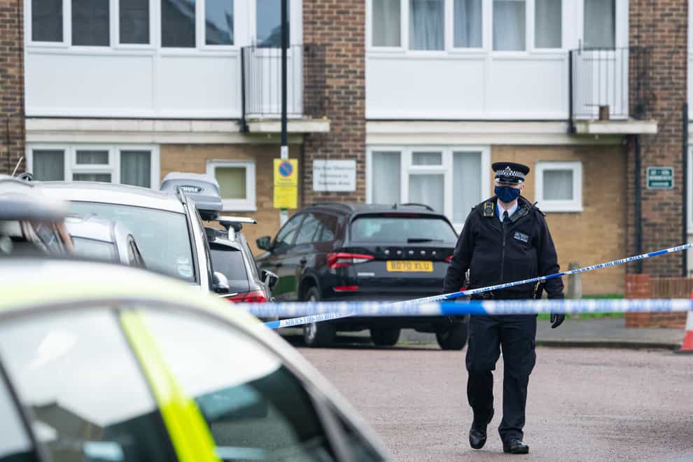 A police officer at the scene of a fatal stabbing at flats on Wisbeach Road in Croydon, London