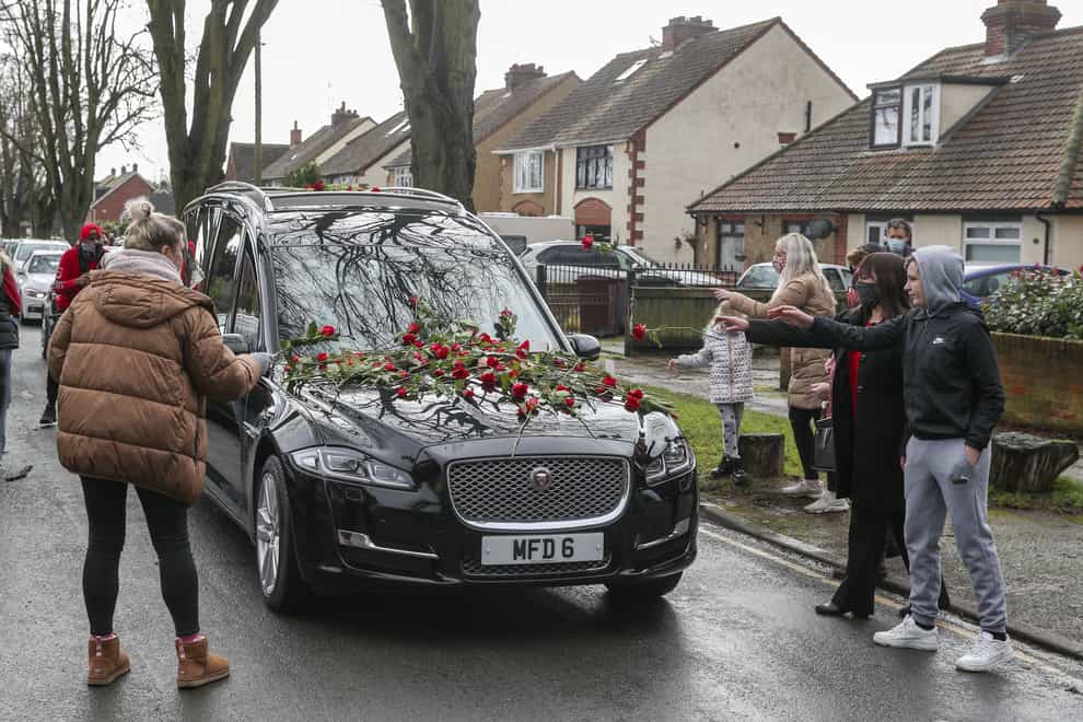 A hearse covered with flowers at Olly Stephens' funeral