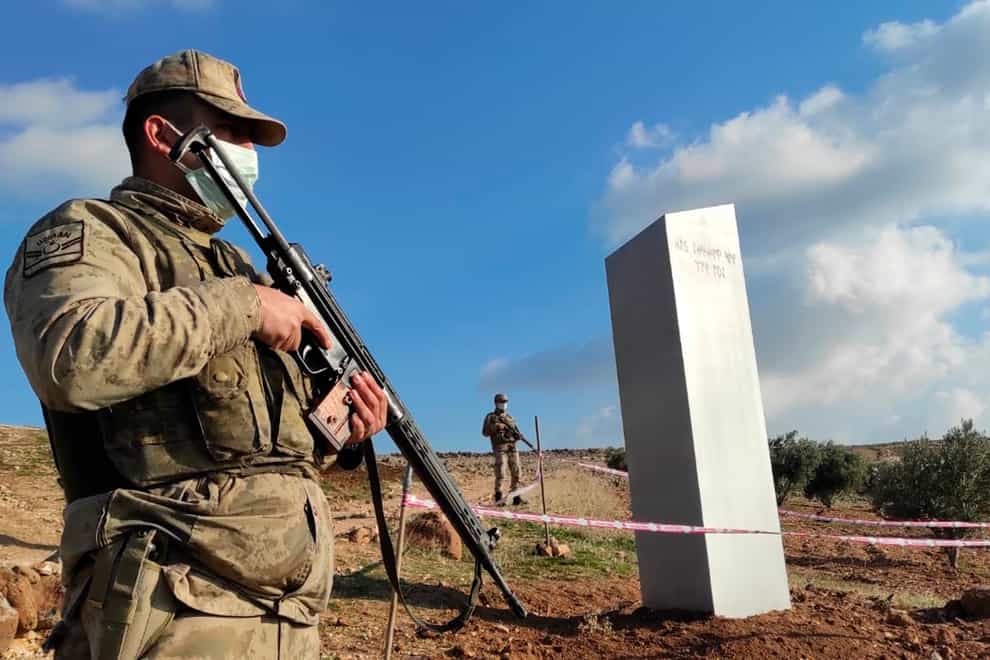 Turkish police officers guard a monolith