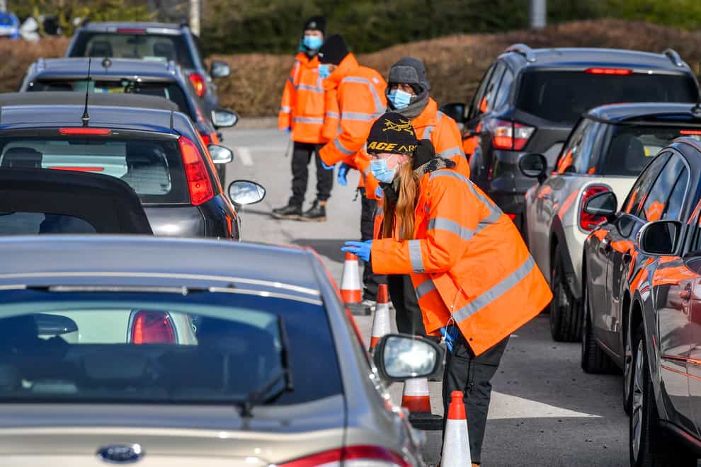 Testing staff hand out kits to motorists attending a Covid-19 surge testing centre at the Science Park, Emersons Green, in Bristol (Ben Birchall/PA)