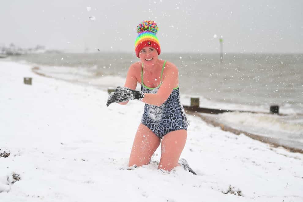 Swimmer Victoria Carlin plays with the snow at the beach in Thorpe Bay, Essex