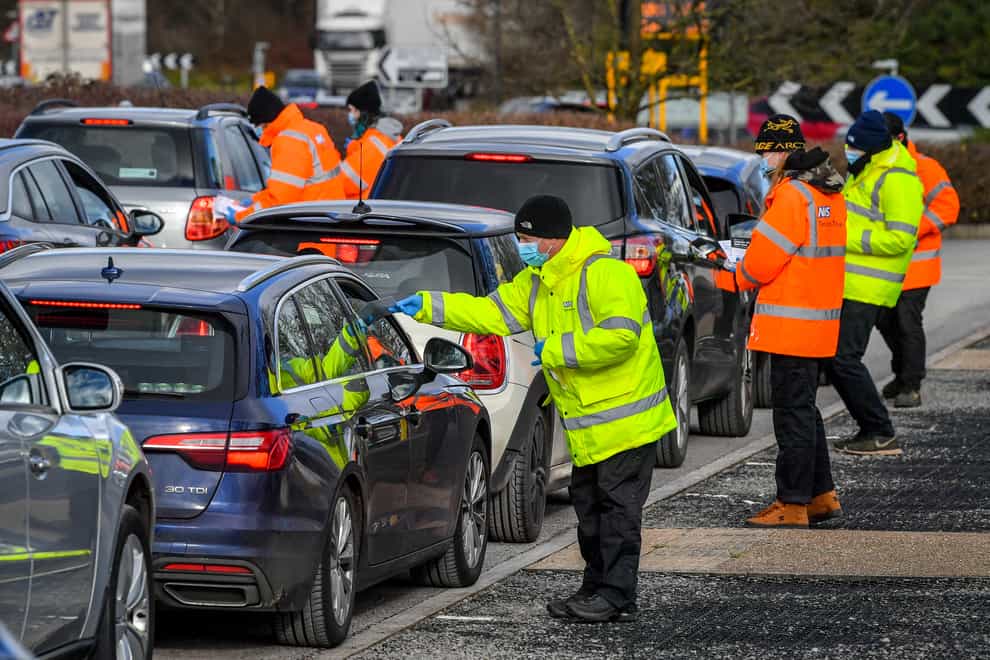 Testing staff hand out kits to motorists attending a surge testing centre at the Science Park, Emersons Green, in Bristol