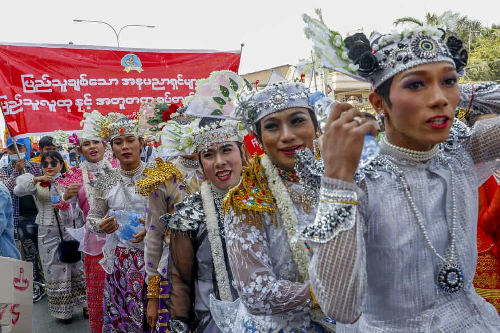 Demonstrators in traditional dancing costumes march against the military coup in Mandalay, Myanmar, on Thursday