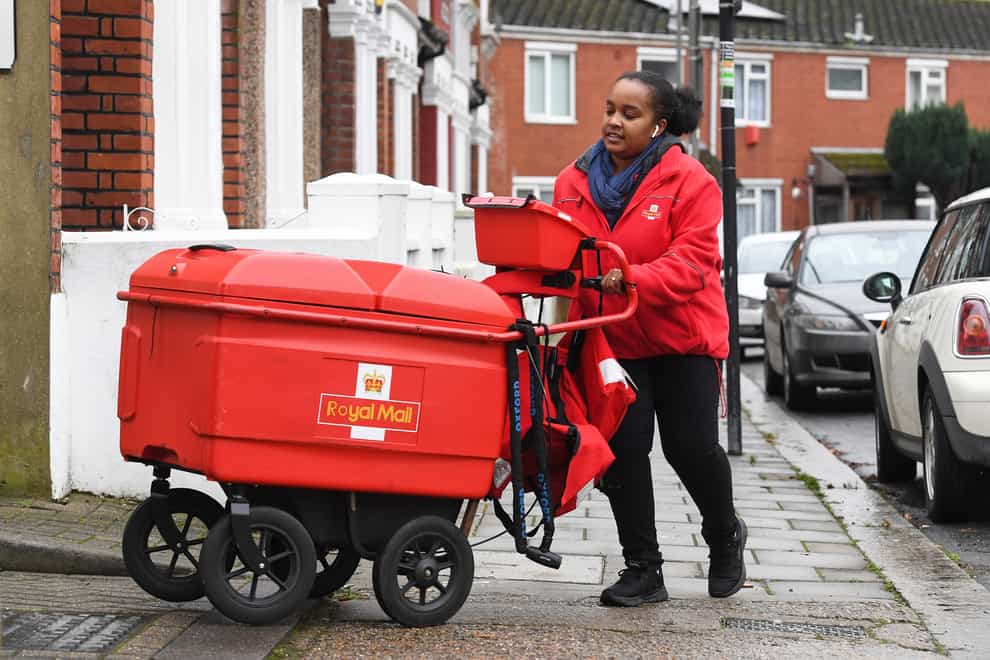 A Royal Mail worker delivers post