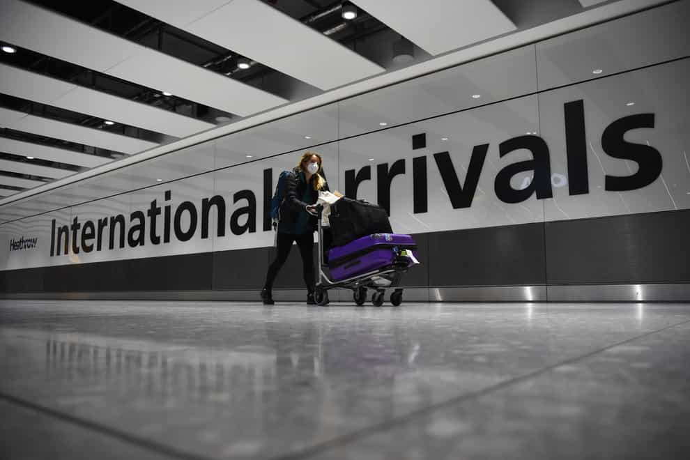 A passenger pushing luggage through Terminal 5 at London’s Heathrow Airport