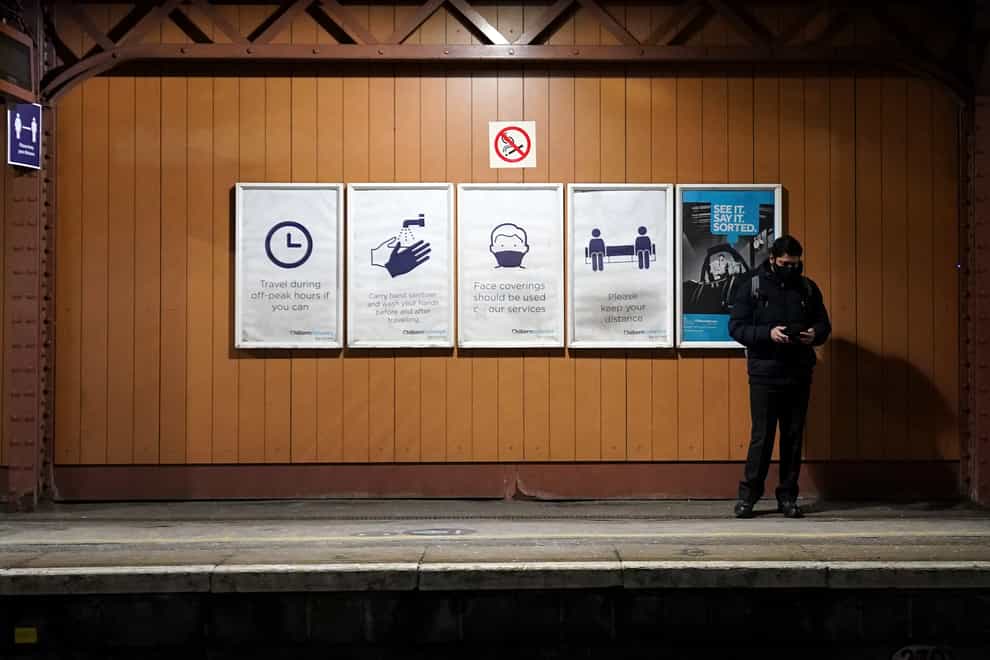 A man stands next to coronavirus information signs on the platform at Moor Street station in Birmingham (Zac Goodwin/PA)