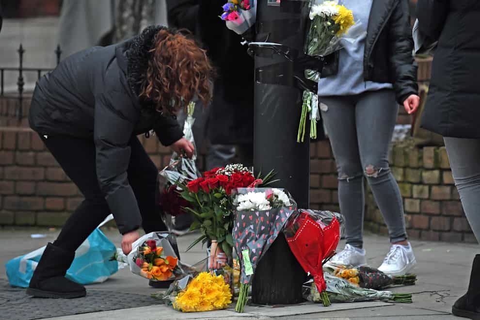 A woman lays a floral tribute on Ackmar Road near Parsons Green Tube station (Kirsty O'Connor/PA)
