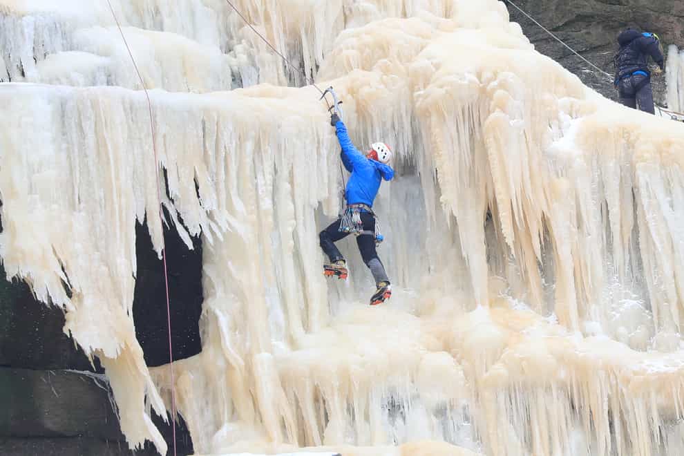 People ice climb on the frozen Kinder Downfall, High Peak in Derbyshire