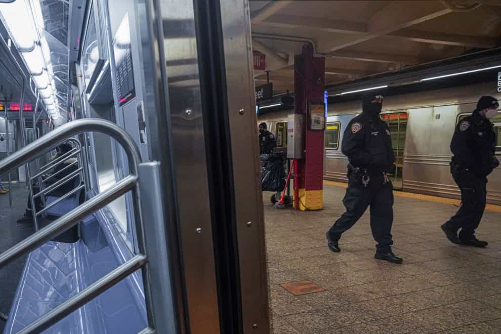 Police patrol the A line subway train bound to Inwood, after NYPD deployed an additional 500 officers into the subway system following deadly attacks (Bebeto Matthews/PA)