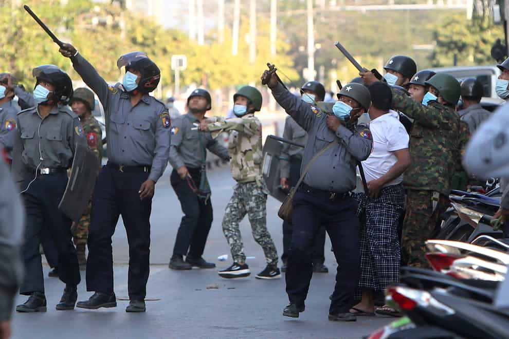 A policeman aims a catapult towards an unknown target during a crackdown on anti-coup protesters holding a rally in front of the Myanmar Economic Bank in Mandalay