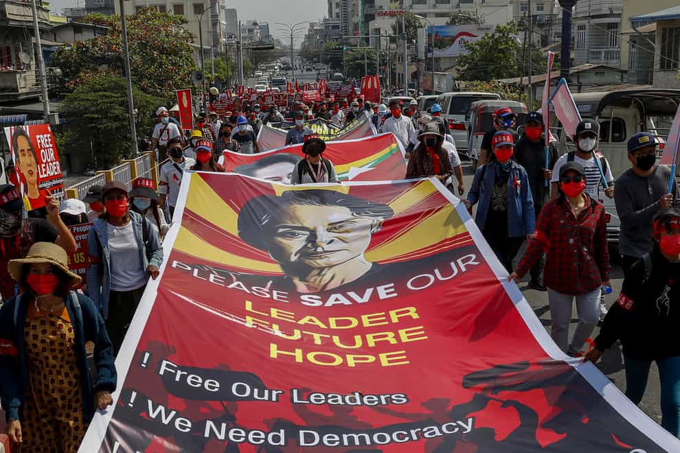 Demonstrators display pictures of detained Myanmar leader Aung San Suu Kyi (AP)