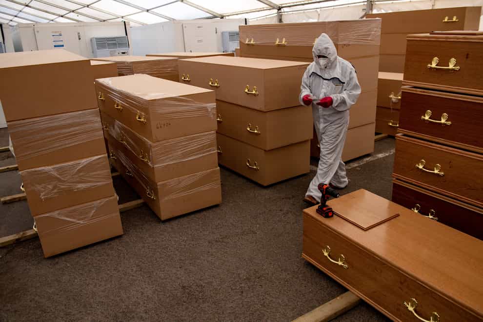 A volunteer walks by coffins at Central Jamia Mosque Ghamkol Sharif in Birmingham in April 2020, which operated as a temporary morgue during the Covid-19 pandemic (Jacob King/PA)