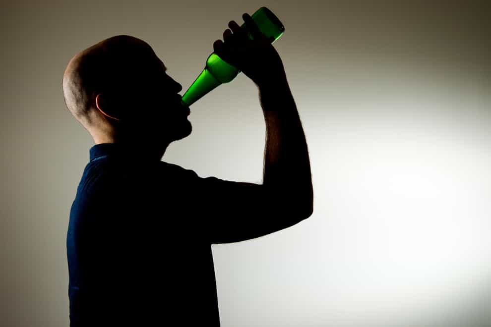 Man drinking from bottle of alcohol