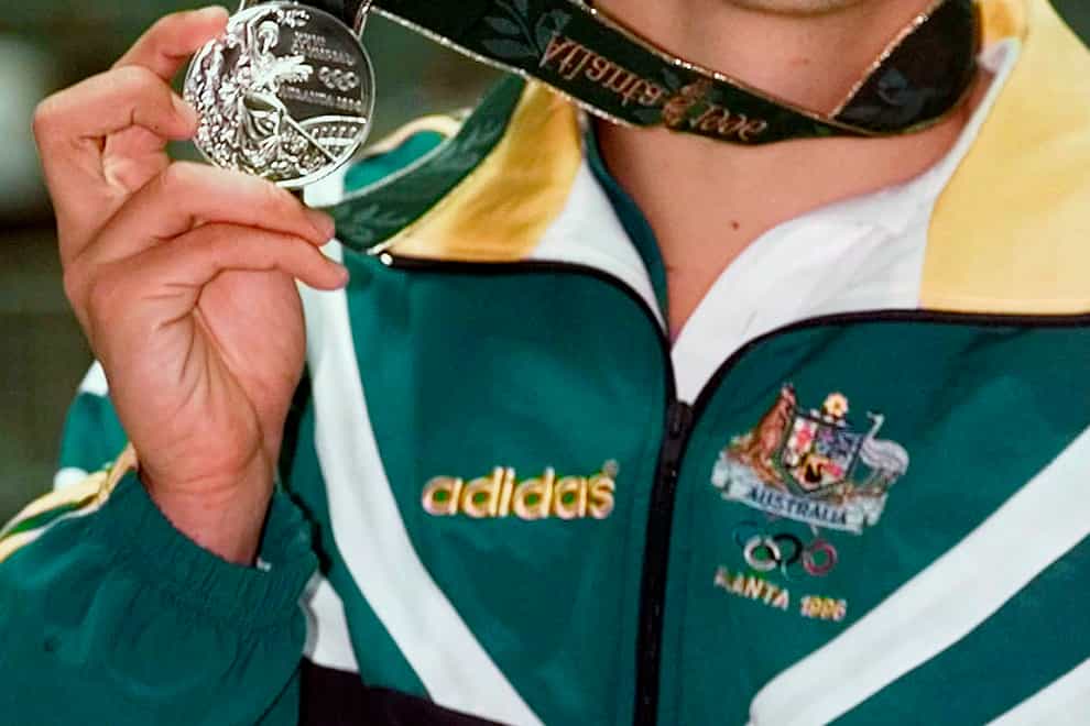 Scott Miller of Australia holds up his silver medal that he won in the men’s 100 metre butterfly at the 1996 Summer Olympics in Atlanta