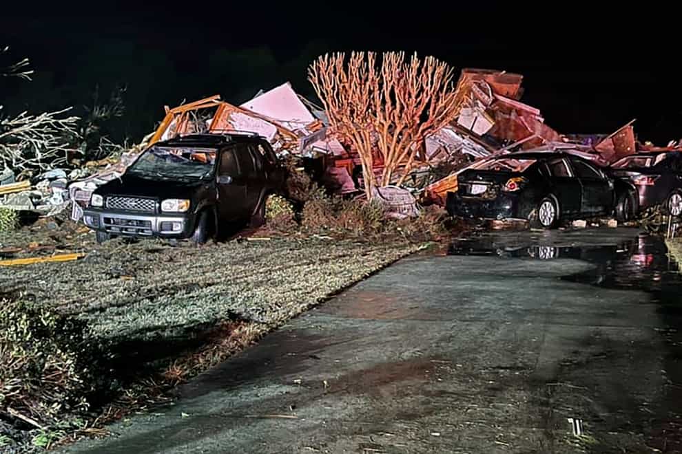 Damaged vehicles sit among debris after a deadly tornado tore through Brunswick County, North Carolina
