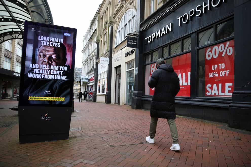 A person makes their way past a government coronavirus sign on Old Christchurch Road in Bournemouth (Andrew Matthews/PA)