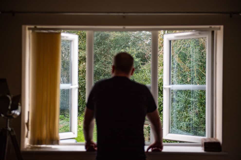 A man looks at his garden from a window