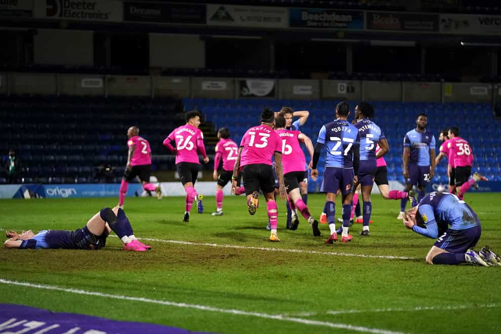 Derby celebrate as Andre Wisdom, far left, scores in stoppage time to leave Wycombe dejected