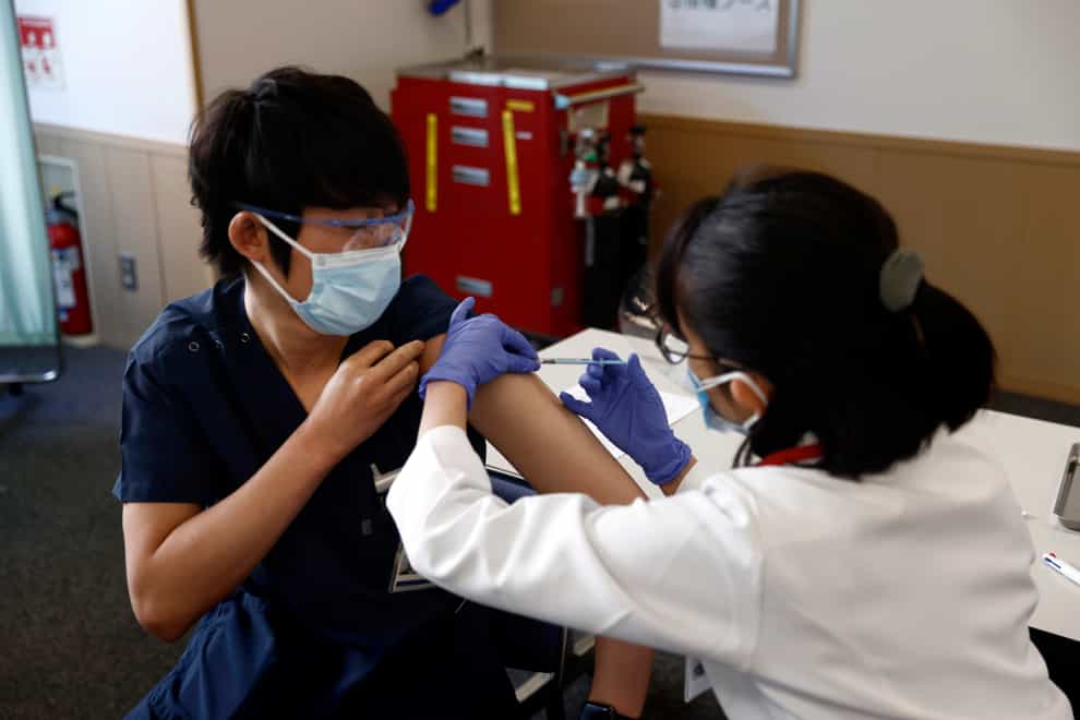 A medical worker receives a dose of Covid-19 vaccine at Tokyo Medical Centre (Behrouz Mehri/AP)