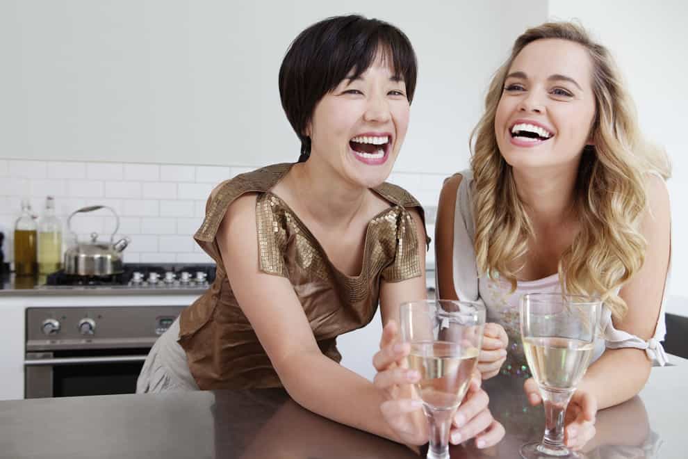 Laughing women drinking wine together