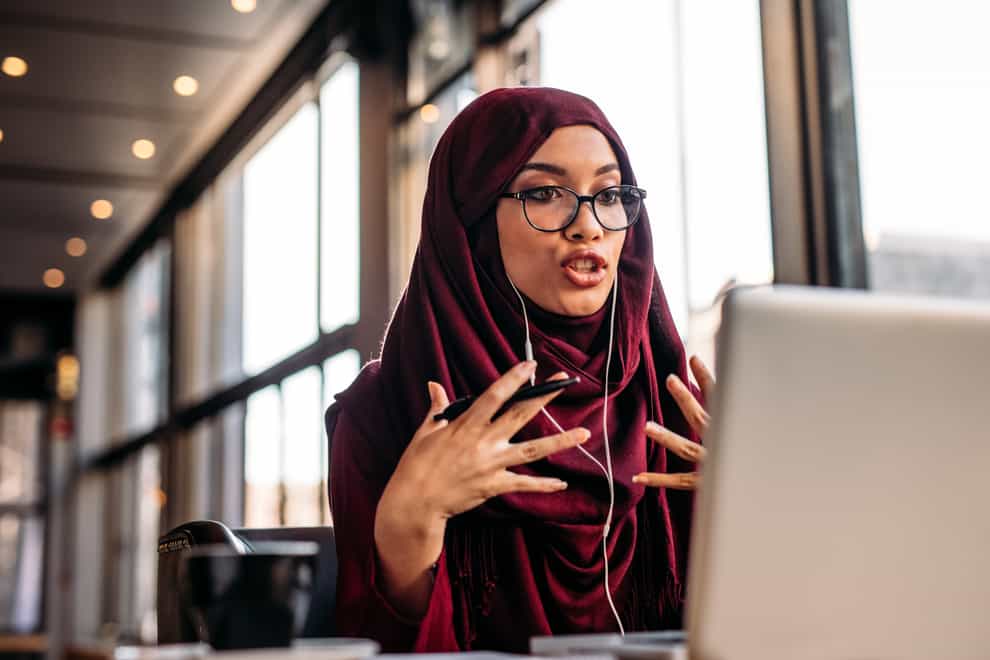 Muslim woman talking during a remote work meeting on a laptop